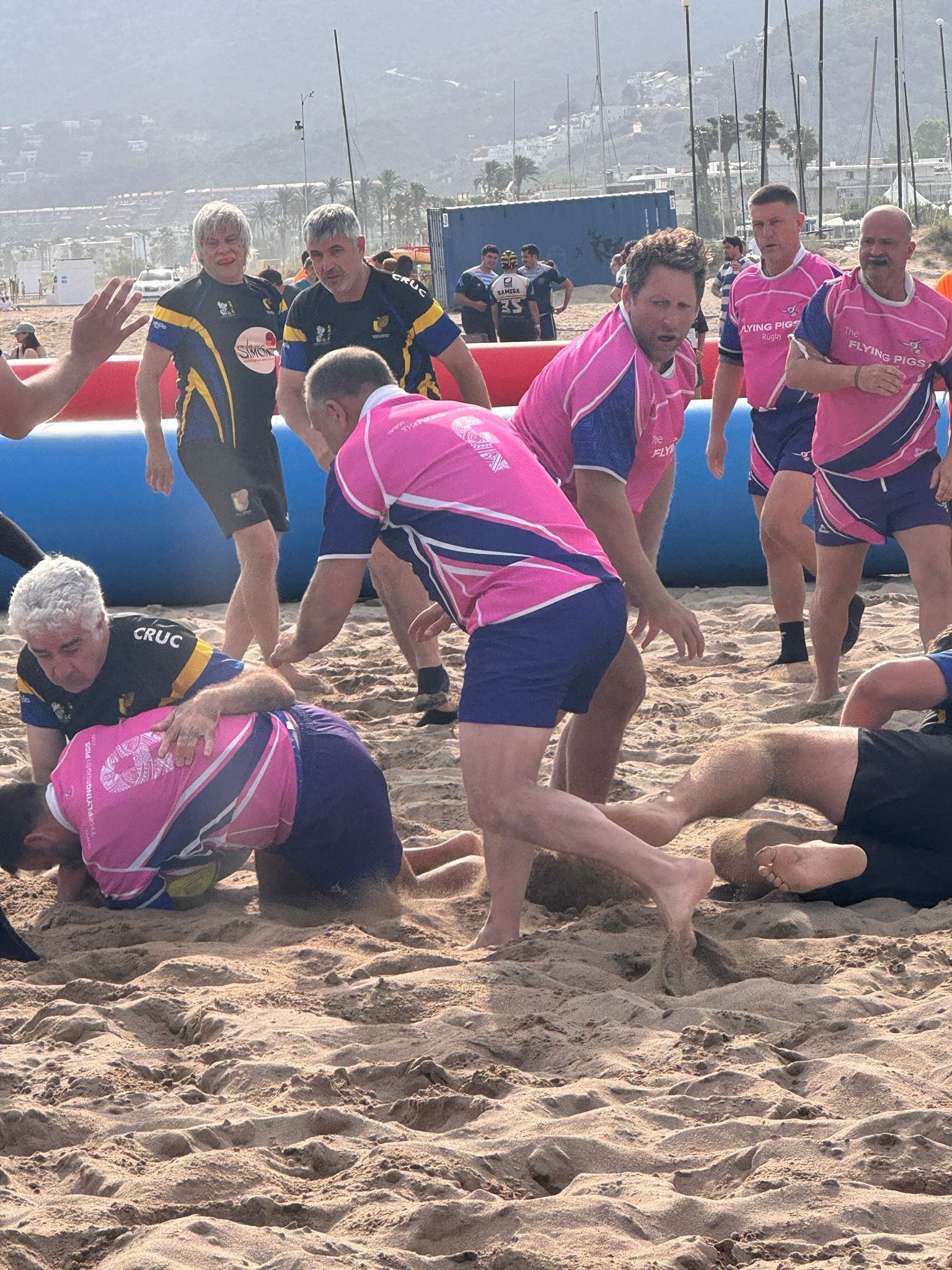 Jugadors dels Flying Rugby Pigs disputant un ruck a la sorra