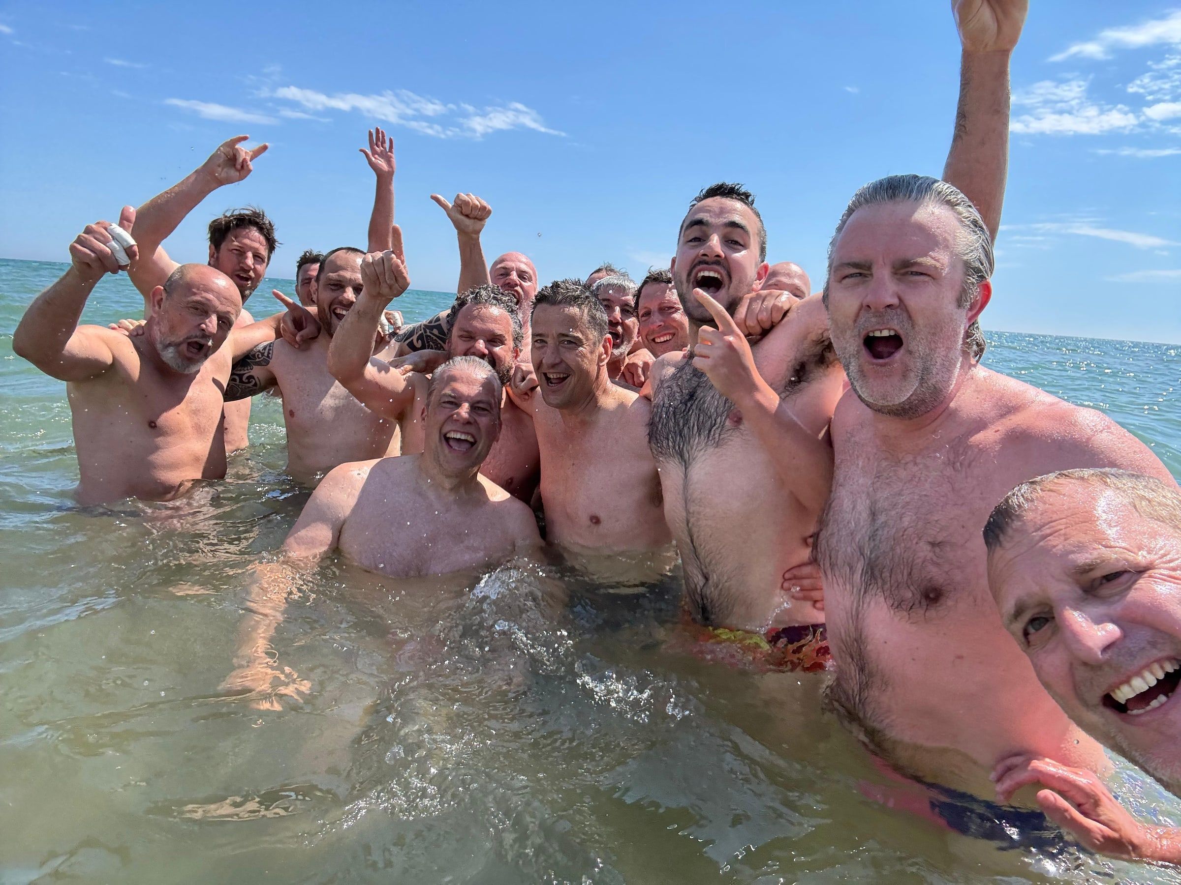 Els Pigs celebrant dins del mar amb els braços enlaire després de jugar